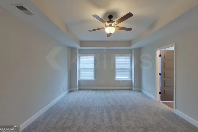 an empty room with closet and windows