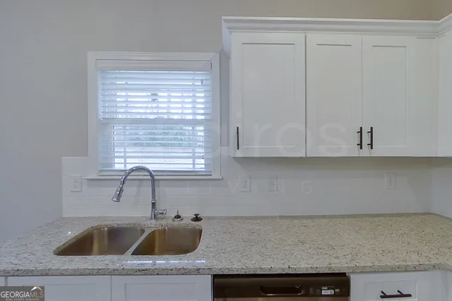a kitchen with granite countertop a sink and cabinets