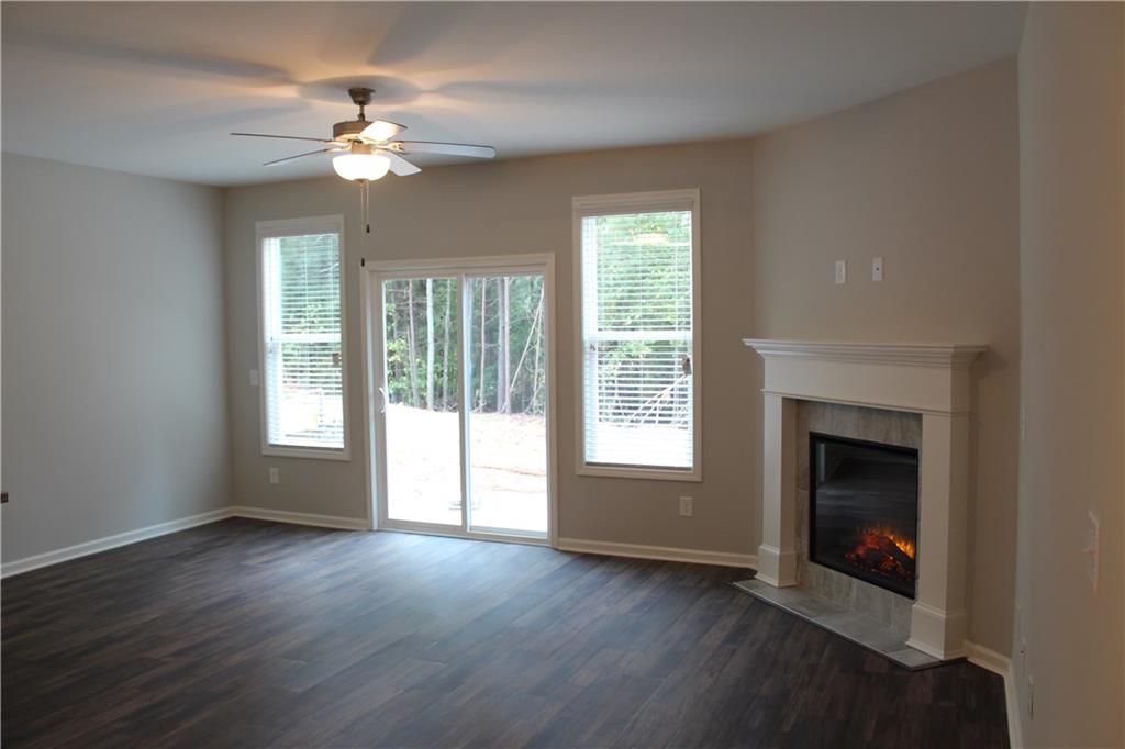 4741 Beacon Ridge Lane Flowery Branch, GA 30542 - Photo 2 of 15 a view of an empty room with wooden floor fireplace and a window