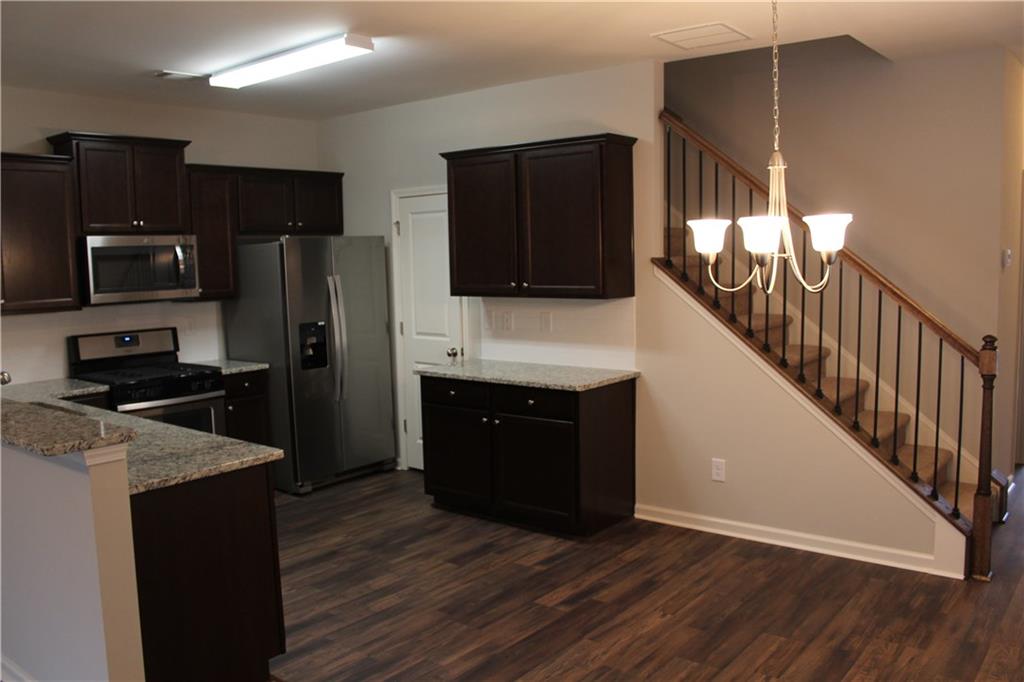 4741 Beacon Ridge Lane Flowery Branch, GA 30542 - Photo 6 of 15 a kitchen with stainless steel appliances granite countertop a refrigerator and a stove top oven