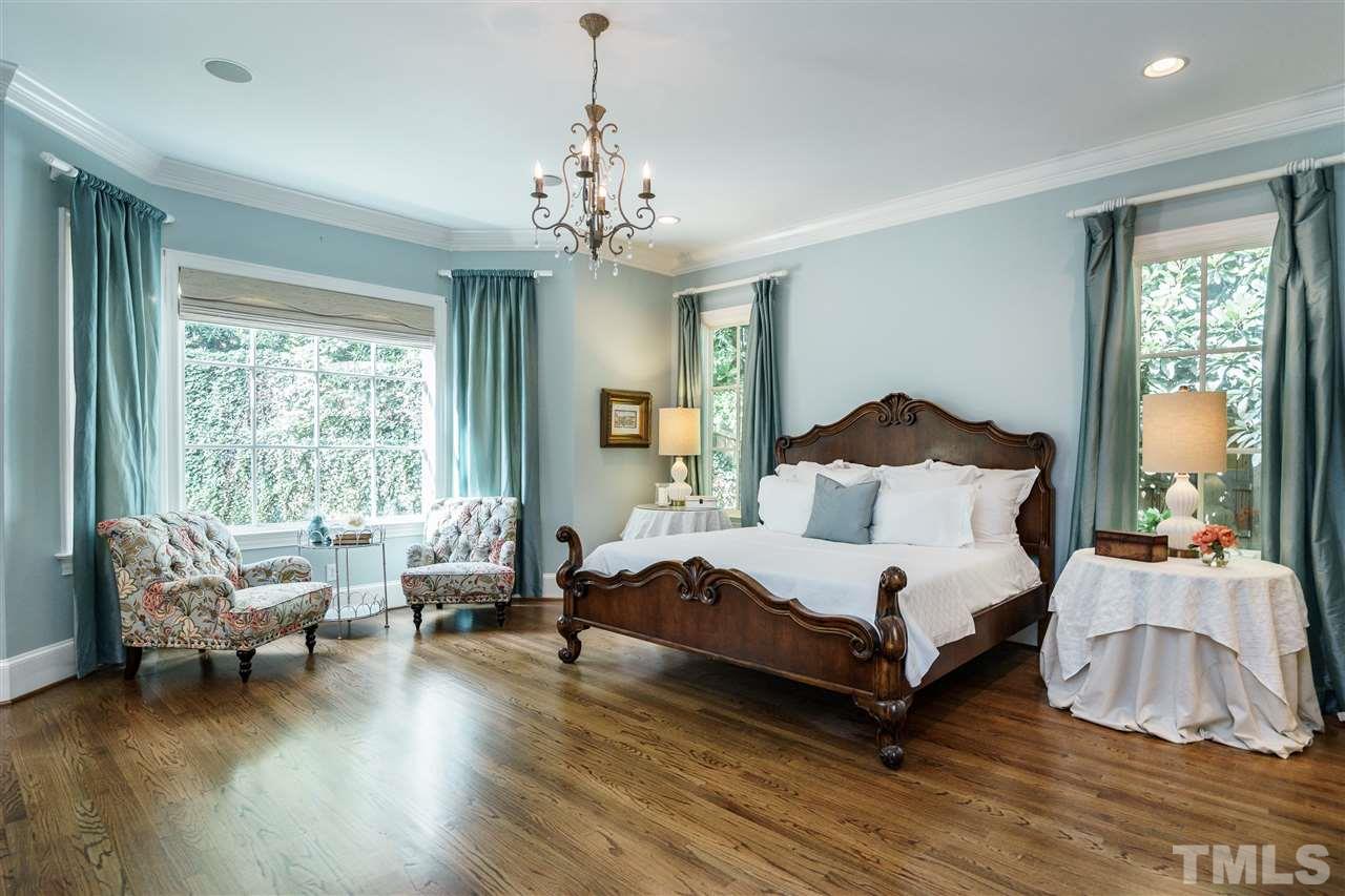 312 Forsyth Street Raleigh, NC 27609 - Photo 8 of 25 a bedroom with a bed and a chandelier