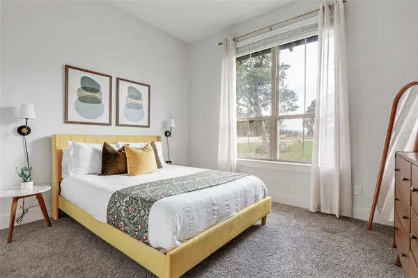 a bedroom with a bed lamp and a window
