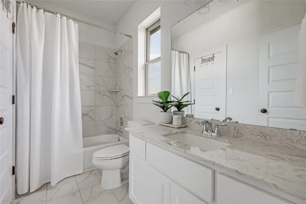 a bathroom with a granite countertop sink a toilet and a large mirror