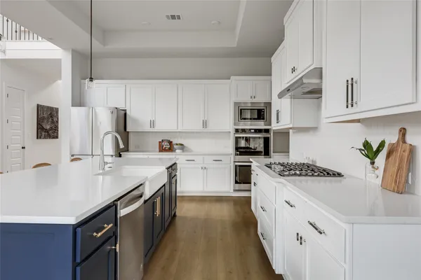 a kitchen with stainless steel appliances granite countertop a sink stove and refrigerator