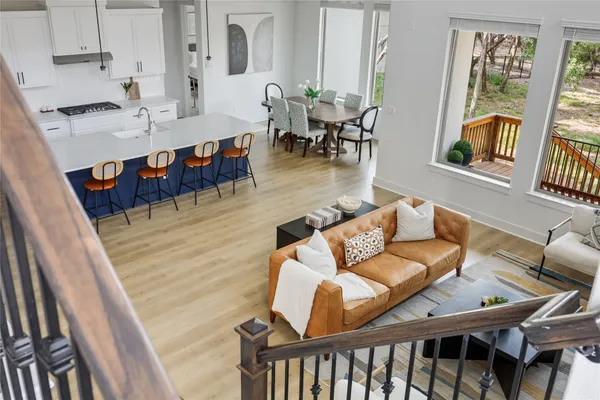 a living room with furniture floor to ceiling window and wooden floor
