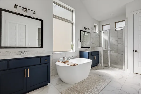 a bathroom with a bathtub sink shower and mirror