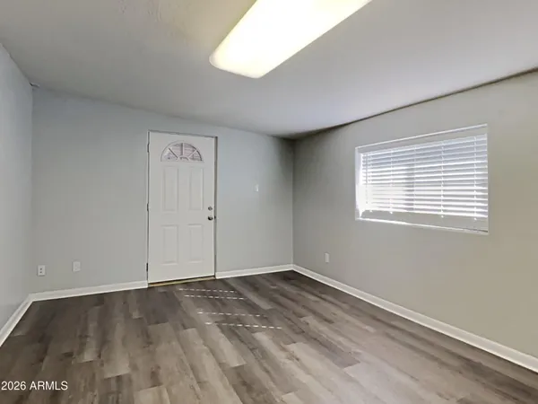 an empty room with wooden floor and windows
