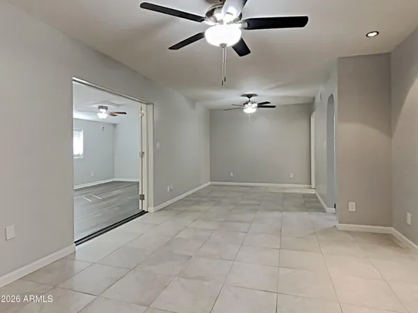 an empty space with a chandelier fan and closet area