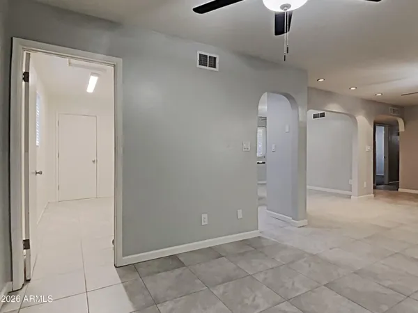 an empty room with fan and entrance