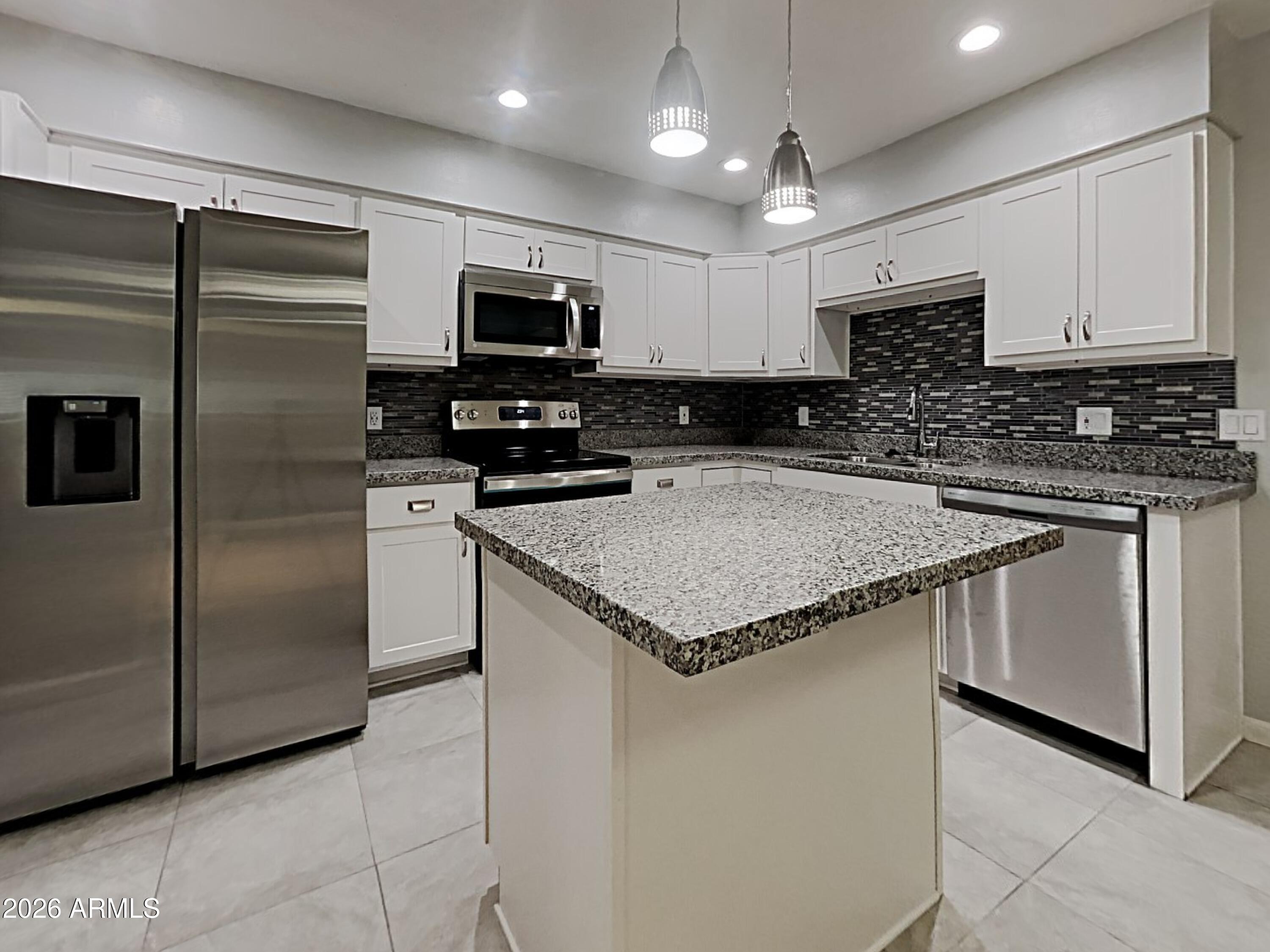 1001 West Villa Rita Drive Phoenix, AZ 85023 - Photo 7 of 26 a kitchen with stainless steel appliances granite countertop a sink a microwave a refrigerator and a stove
