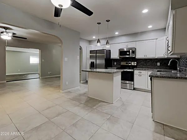 a kitchen with stainless steel appliances granite countertop a sink and a stove