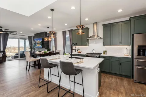 a kitchen with stainless steel appliances white cabinets and a refrigerator