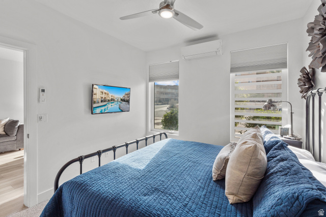 1122 South 1790th West, Unit 1 St. George, UT 84770 - Photo 14 of 37 Bright bedroom featuring a ceiling fan with integrated lighting, wall-mounted display, and two windows with privacy blinds