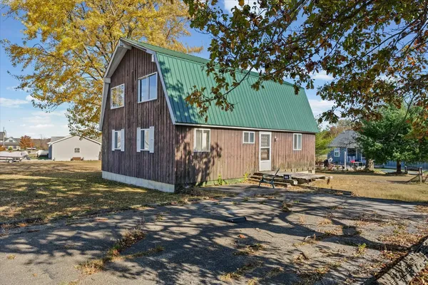 a view of a house with a tree in front of it