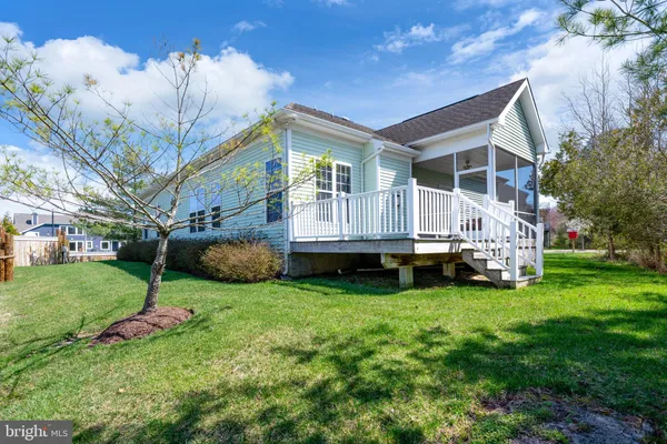 a view of a house with backyard and a tree