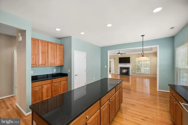 a kitchen with granite countertop a stove and wooden floor