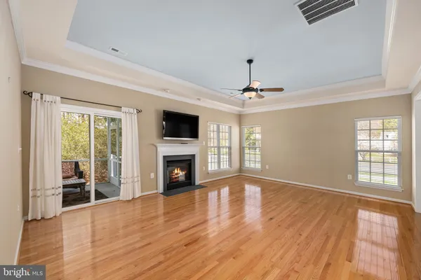 a view of empty room with wooden floor and fireplace