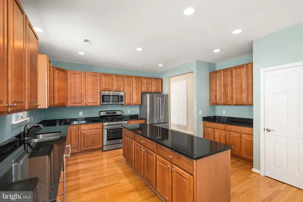 a kitchen with stainless steel appliances granite countertop a stove a sink and a refrigerator