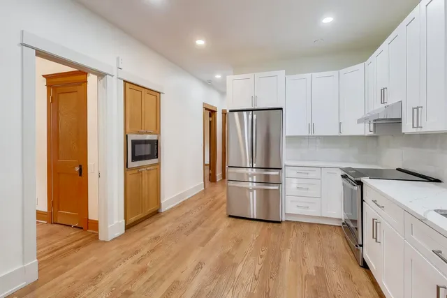 a kitchen with stainless steel appliances a refrigerator and a stove top oven