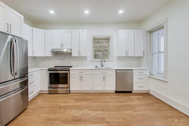 a kitchen with granite countertop white cabinets and white appliances