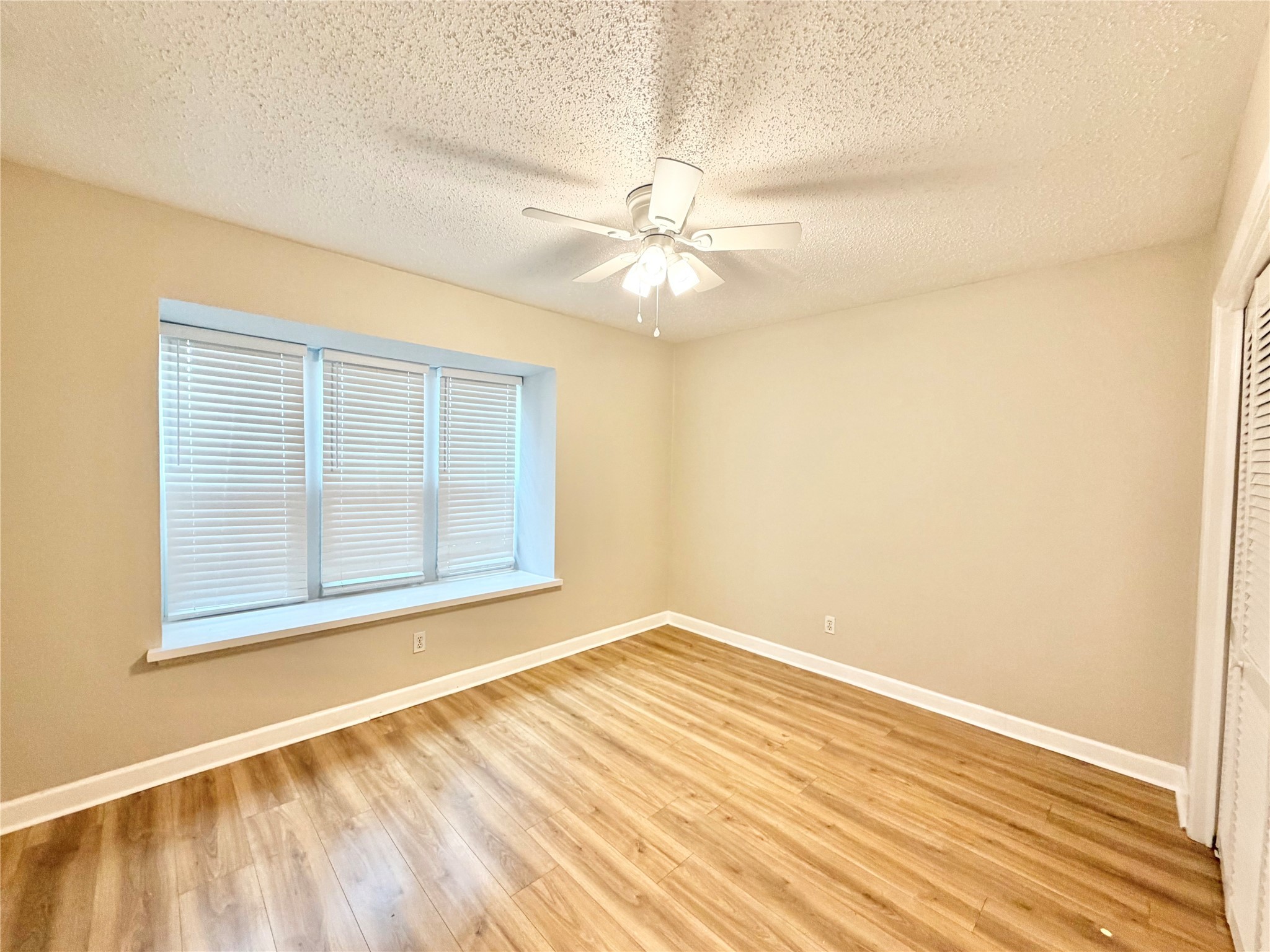 8225 Kingsbrook Road, Unit 116 Houston, TX 77024 - Photo 12 of 21 en empty room with a window and ceiling fan