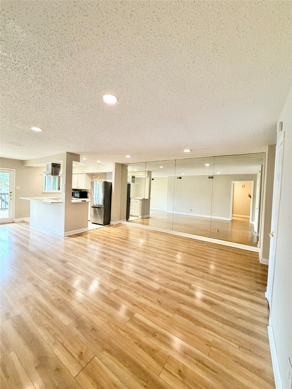 8225 Kingsbrook Road, Unit 116 Houston, TX 77024 - Photo 10 of 21 an empty room with wooden floor and windows