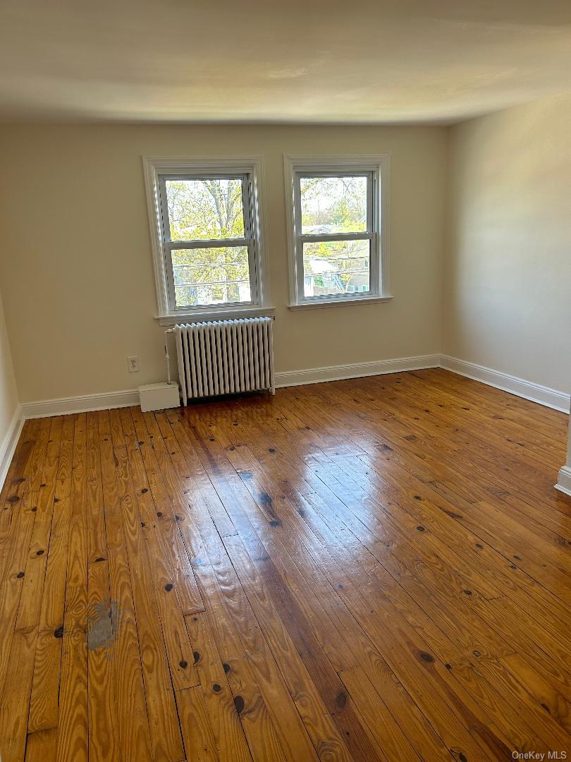 19 Firwood Road, Unit 2 Port Washington, NY 11050 - Photo 4 of 9 Wood-type flooring, radiator heating unit, and baseboards