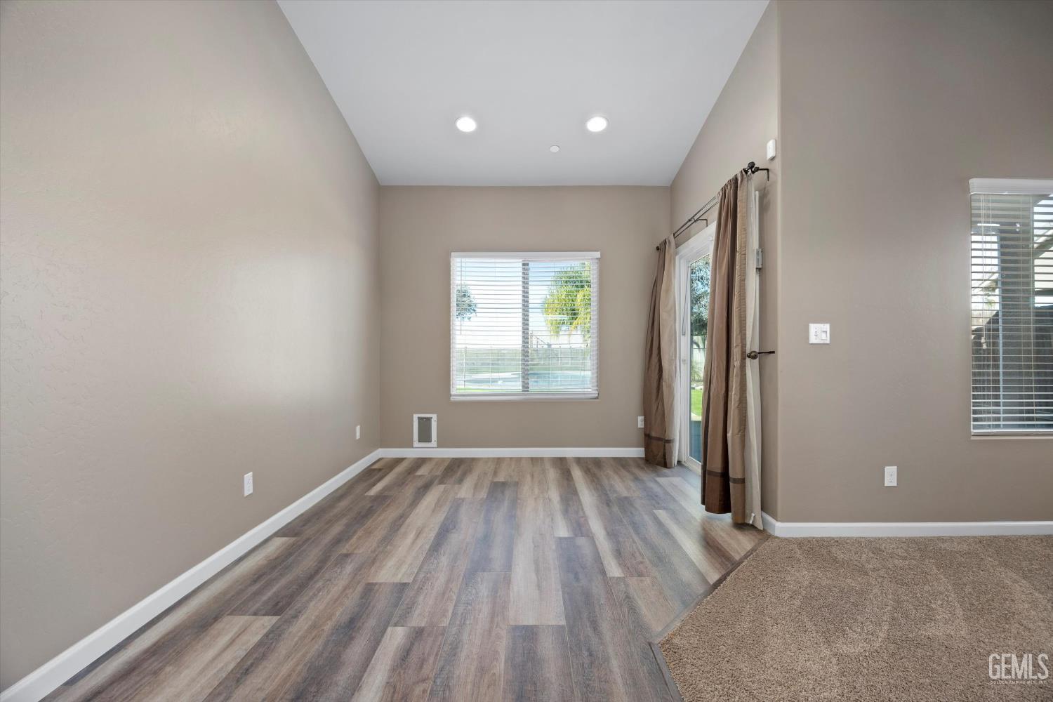 Undisclosed Address Bakersfield, CA 93314 - Photo 14 of 42 an empty room with wooden floor and windows