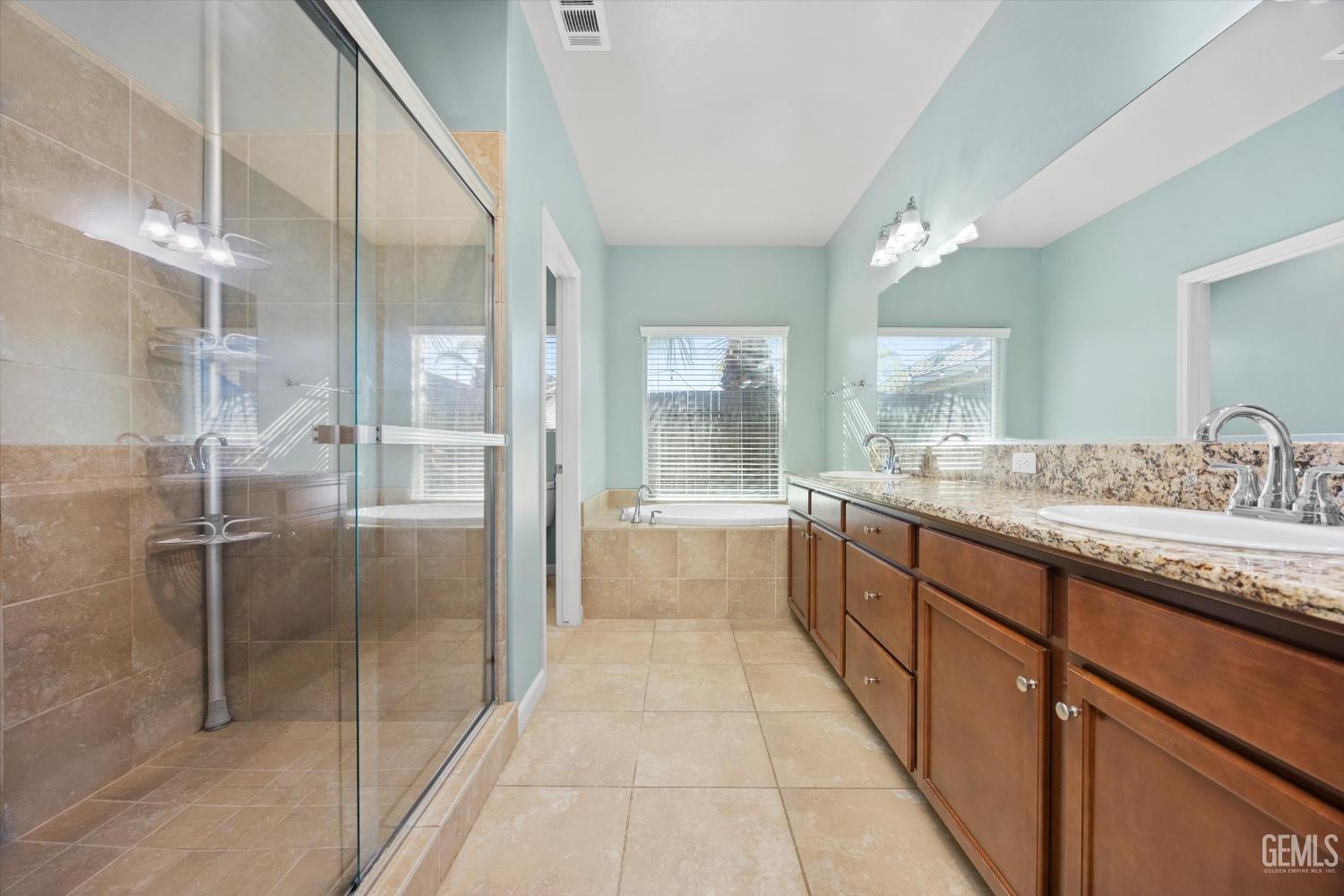 Undisclosed Address Bakersfield, CA 93314 - Photo 24 of 42 a large bathroom with a granite countertop sink mirror and a bath tub