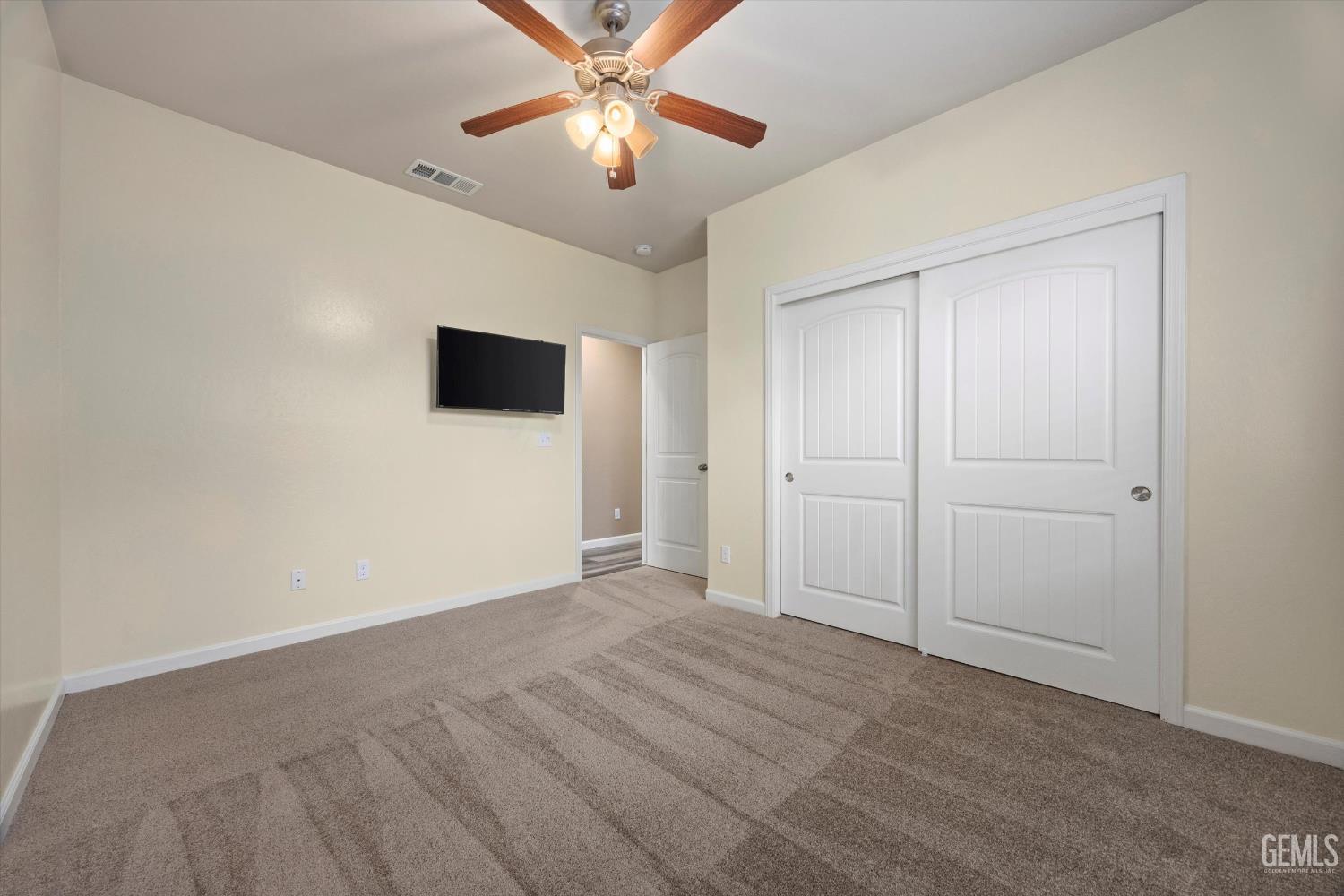 Undisclosed Address Bakersfield, CA 93314 - Photo 32 of 42 an empty room with closet and a chandelier fan
