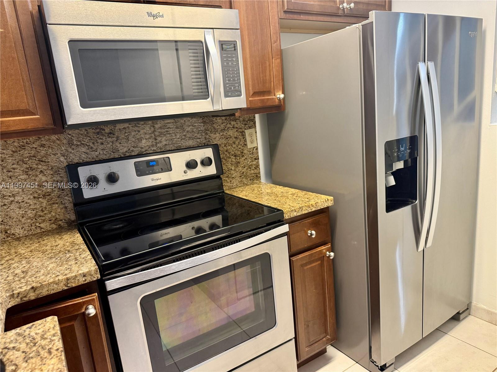 9435 Southwest 140th Court, Unit 9435 Miami, FL 33186 - Photo 20 of 33 a stove top oven sitting inside of a kitchen