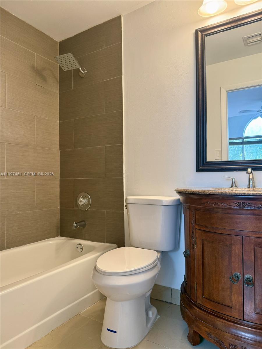 9435 Southwest 140th Court, Unit 9435 Miami, FL 33186 - Photo 30 of 33 a bathroom with a toilet a sink and bathtub