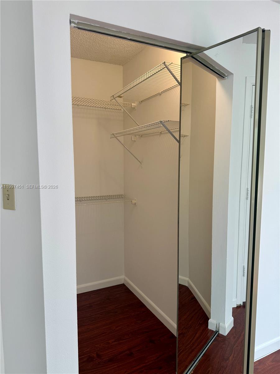 9435 Southwest 140th Court, Unit 9435 Miami, FL 33186 - Photo 33 of 33 a view of an empty room with wooden floor and a door