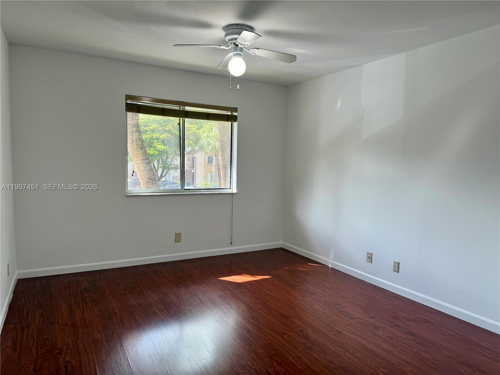 9435 Southwest 140th Court, Unit 9435 Miami, FL 33186 - Photo 10 of 33 a view of empty room with wooden floor and fan