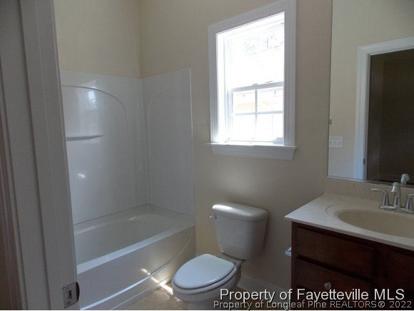 344 Kerr Lake Road Aberdeen, NC 28315 - Photo 16 of 25 a bathroom with a toilet a sink a bathtub and next to a window