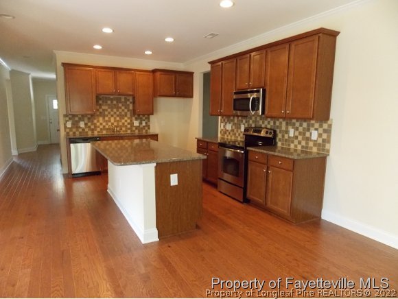 344 Kerr Lake Road Aberdeen, NC 28315 - Photo 4 of 25 a kitchen with stainless steel appliances granite countertop a stove a sink dishwasher and a microwave with wooden floor