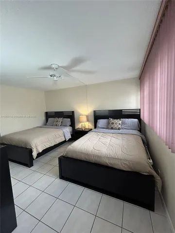 a bedroom with two beds and a lamp