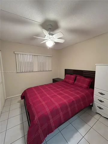 a bedroom with a large bed and a ceiling fan