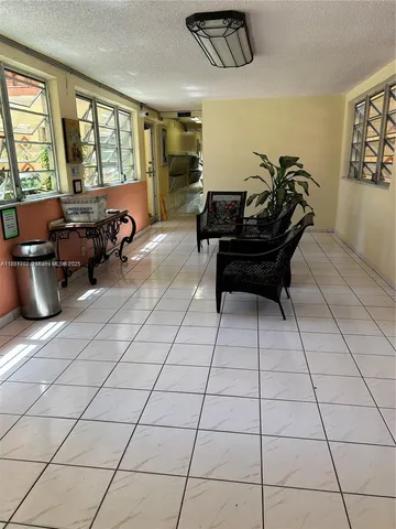 a living room with furniture and a floor to ceiling window