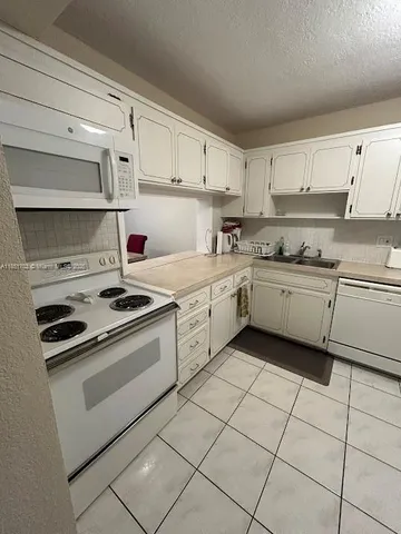 a kitchen with a stove sink and cabinets