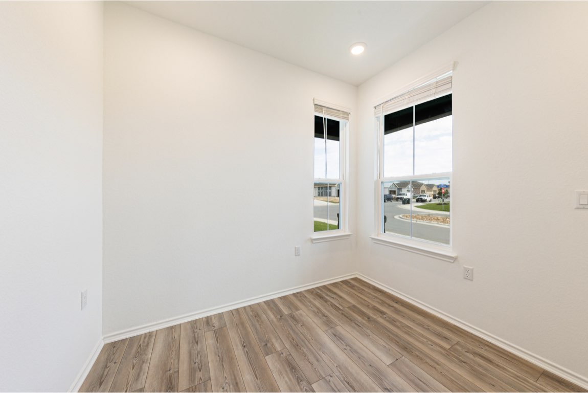 201 Coachsmith Street Georgetown, TX 78633 - Photo 13 of 32 an empty room with wooden floor and windows