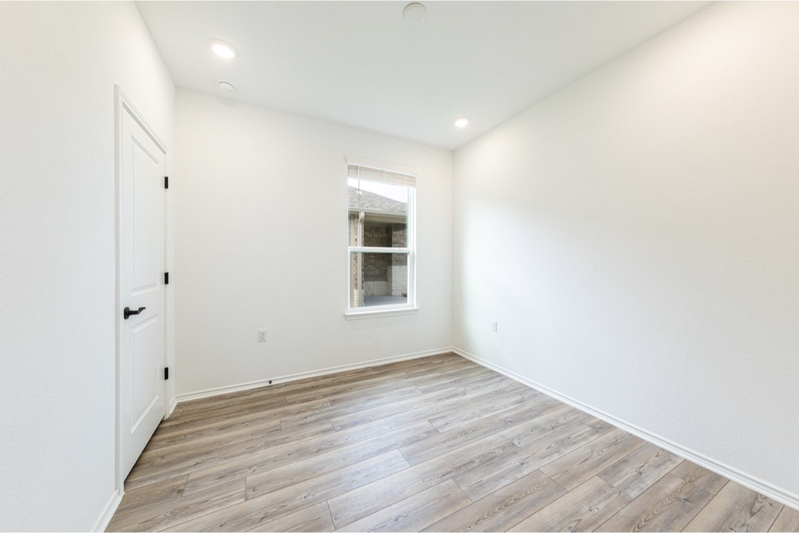201 Coachsmith Street Georgetown, TX 78633 - Photo 14 of 32 an empty room with wooden floor and windows