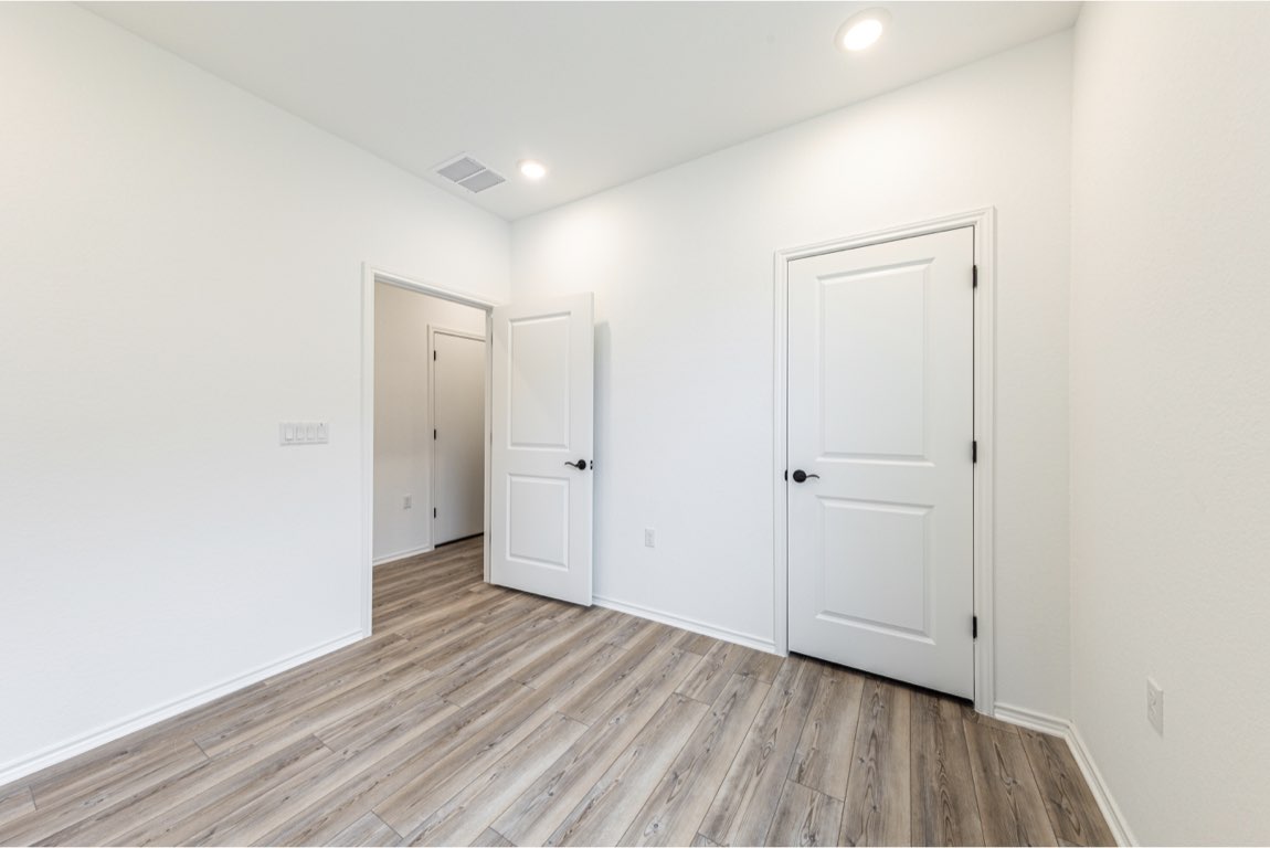 201 Coachsmith Street Georgetown, TX 78633 - Photo 15 of 32 a view of an empty room with wooden floor