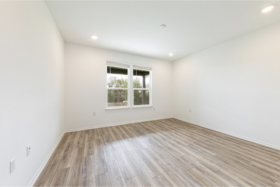 201 Coachsmith Street Georgetown, TX 78633 - Photo 19 of 32 an empty room with wooden floor and windows