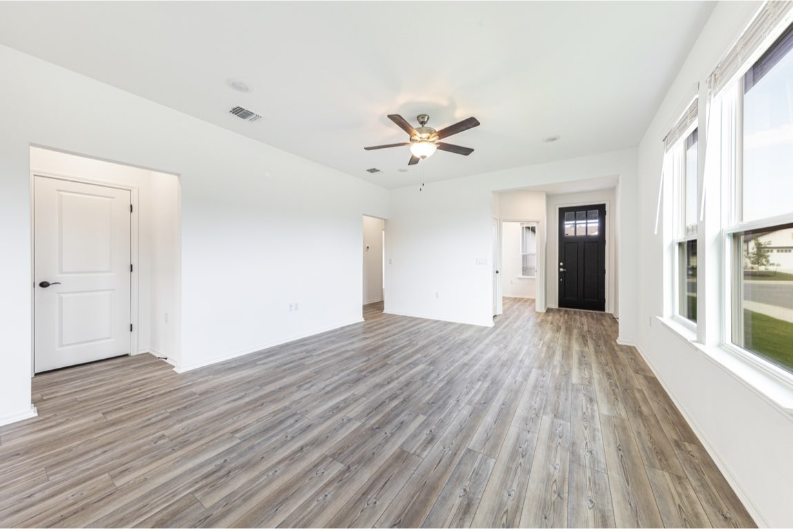 201 Coachsmith Street Georgetown, TX 78633 - Photo 5 of 32 wooden floor in an empty room with a window