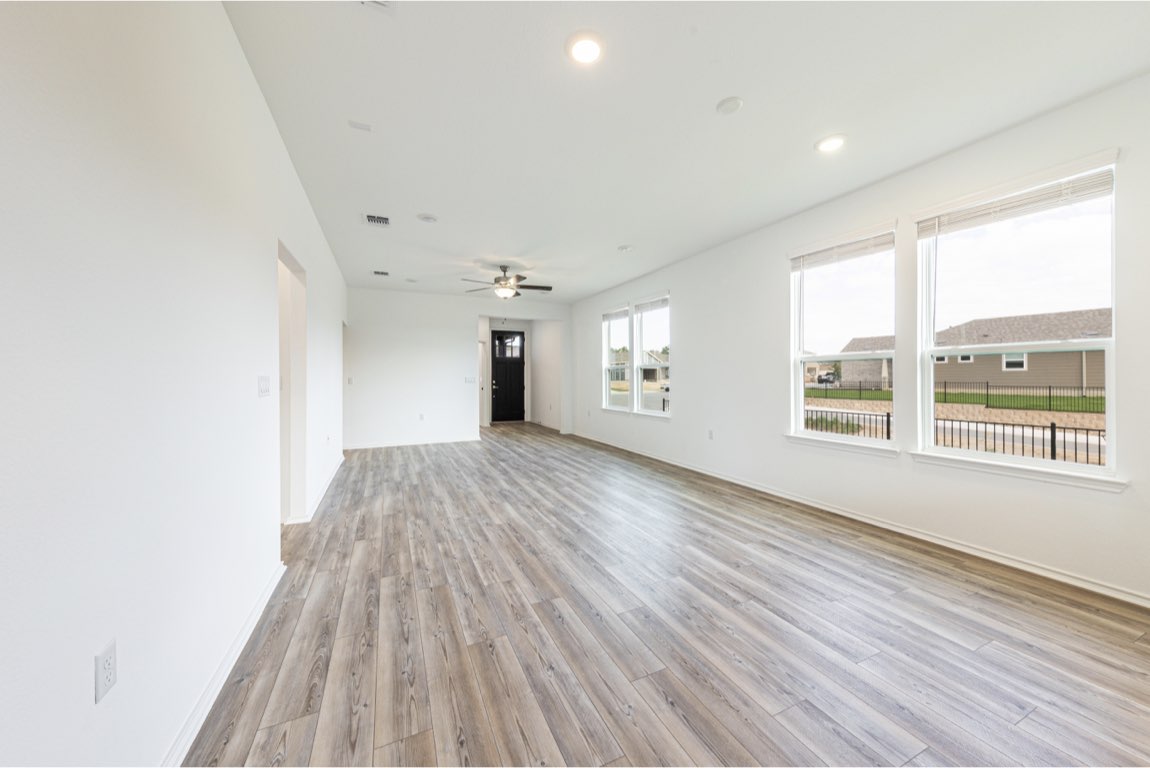 201 Coachsmith Street Georgetown, TX 78633 - Photo 6 of 32 a view of an empty room with wooden floor and a window