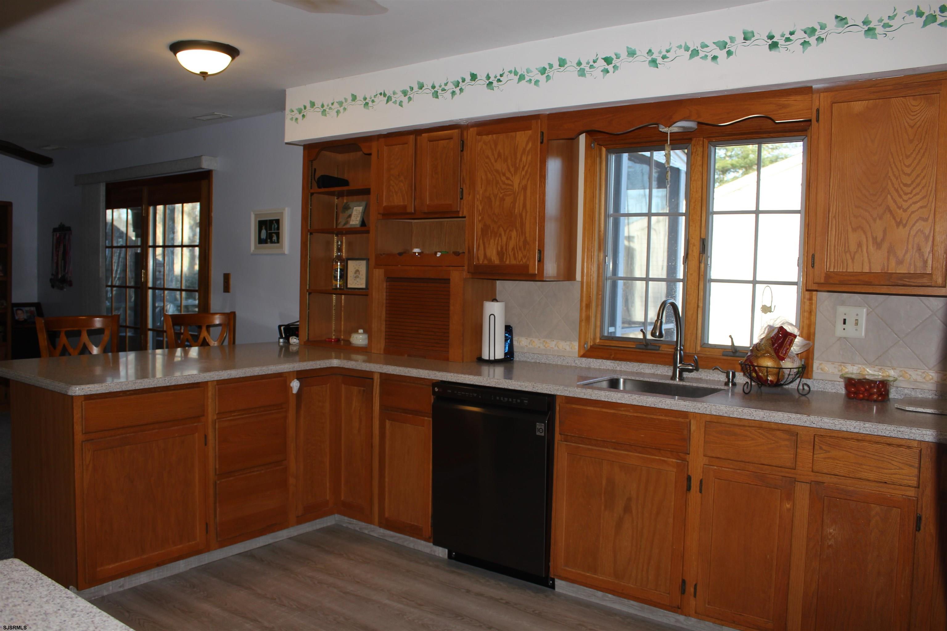 710 Pitney Road Absecon, NJ 08201 - Photo 8 of 30 a kitchen with stainless steel appliances wooden cabinets a sink and a large window
