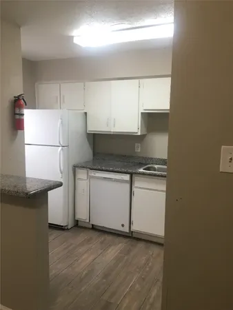 a kitchen with granite countertop white cabinets and white appliances