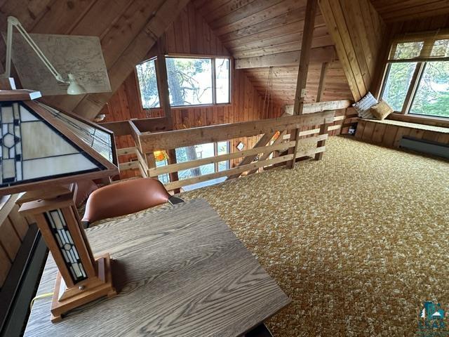 2763 Van Vac Road Ely, MN 55731 - Photo 19 of 37 Carpeted loft area featuring wood paneling, an angled ceiling, and multiple windows