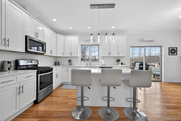 a kitchen with a sink a stove a refrigerator and white cabinets